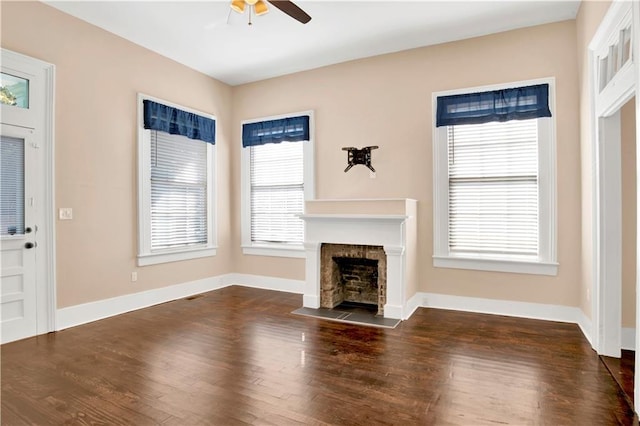 unfurnished living room with ceiling fan, a wealth of natural light, and dark hardwood / wood-style floors