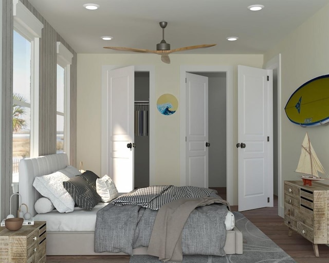 bedroom with multiple windows, ceiling fan, a closet, and dark wood-type flooring