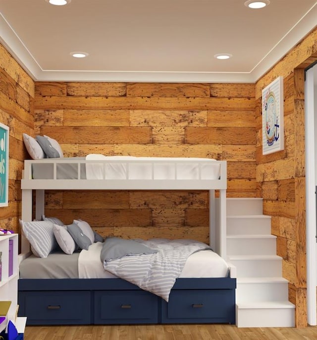 bedroom featuring wood-type flooring and rustic walls