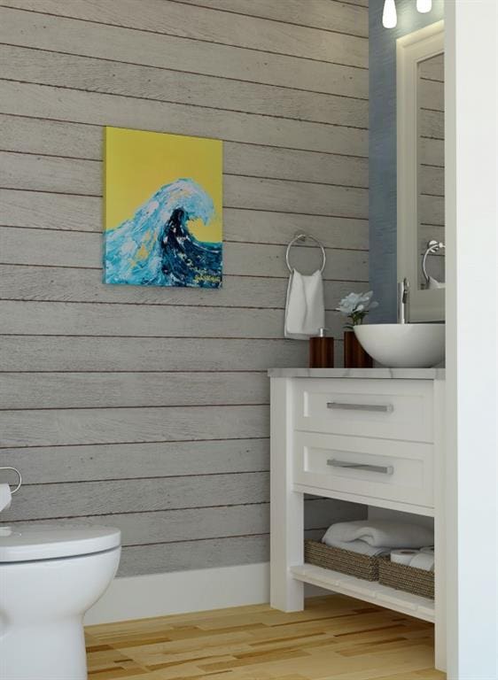 bathroom with vanity, hardwood / wood-style flooring, toilet, and wooden walls