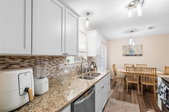 kitchen with stainless steel dishwasher, decorative light fixtures, sink, and white cabinets