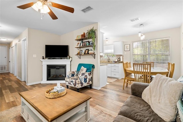 living room with ceiling fan and light hardwood / wood-style floors