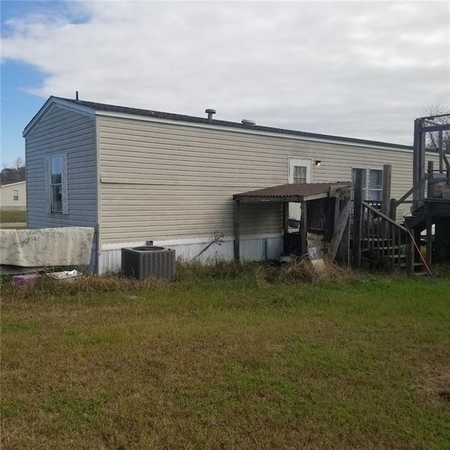 back of property featuring a yard and cooling unit