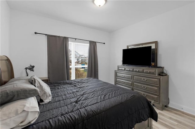 bedroom featuring light wood-style floors and baseboards