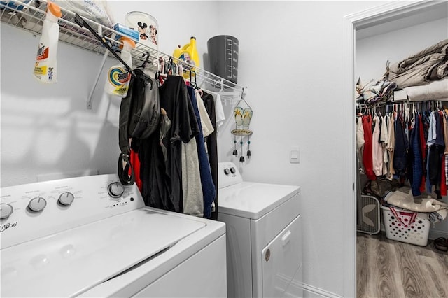 laundry room featuring laundry area, wood finished floors, and washer and clothes dryer