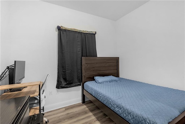 bedroom featuring baseboards and wood finished floors