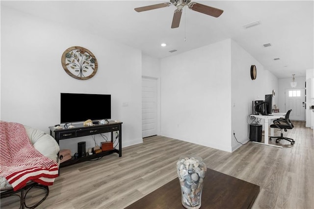 living room featuring visible vents, baseboards, and wood finished floors