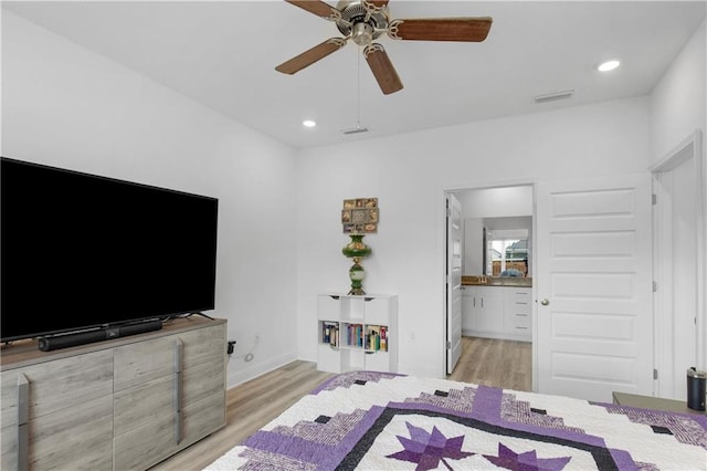 bedroom featuring recessed lighting, visible vents, light wood-style floors, and ensuite bath