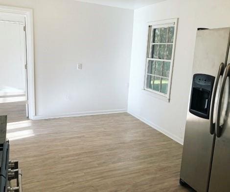 interior space with stainless steel fridge with ice dispenser and wood-type flooring