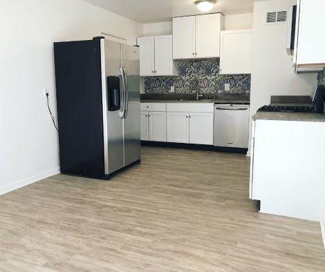 kitchen with sink, white cabinets, stainless steel appliances, and light wood-type flooring