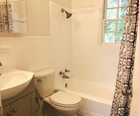 full bathroom featuring toilet, shower / tub combo with curtain, vanity, and tile walls