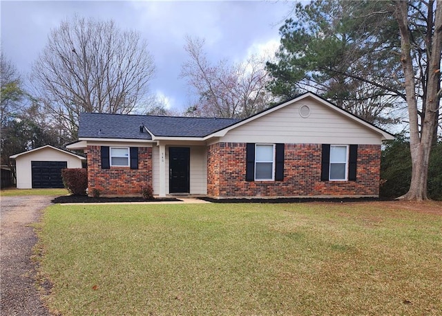 single story home featuring a garage, an outdoor structure, and a front yard