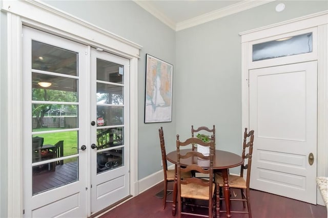 dining space with dark hardwood / wood-style floors, crown molding, and french doors