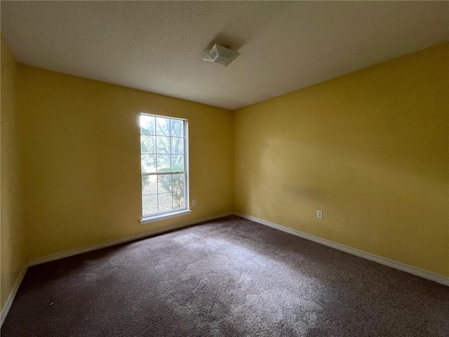 spare room featuring dark carpet