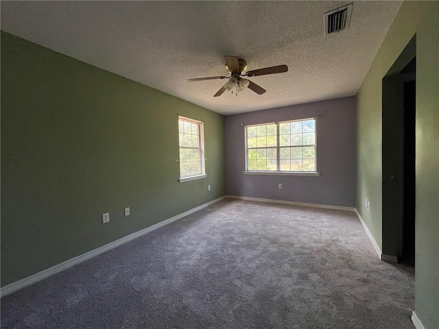 empty room featuring carpet, ceiling fan, and a textured ceiling