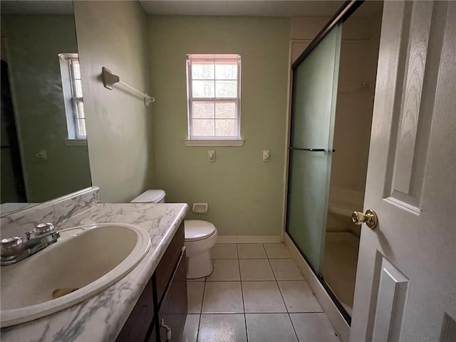 bathroom with tile patterned flooring, vanity, toilet, and a shower with shower door