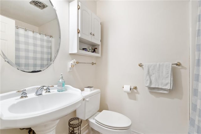 full bathroom featuring toilet, visible vents, and a sink