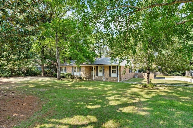 single story home featuring covered porch, a front lawn, and brick siding