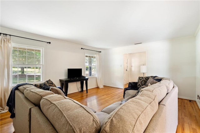 living area with baseboards, visible vents, and light wood finished floors