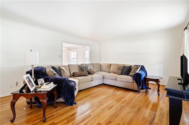 living area featuring ornamental molding, wood finished floors, and baseboards