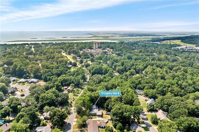 birds eye view of property with a water view and a wooded view