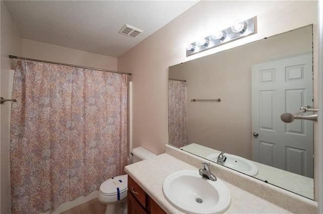 bathroom with vanity, toilet, hardwood / wood-style floors, and a textured ceiling