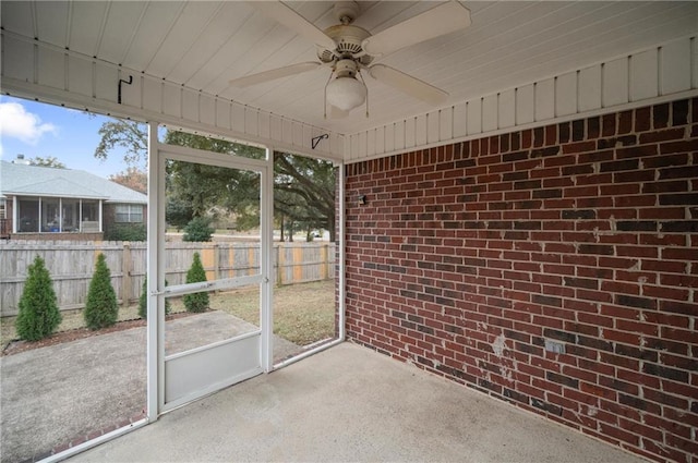 unfurnished sunroom featuring ceiling fan