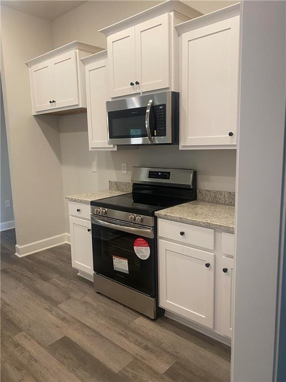 9577 Stone Rd, Semmes, AL 36575 - kitchen featuring stainless steel appliances, dark wood finished floors, white cabinetry, and baseboards