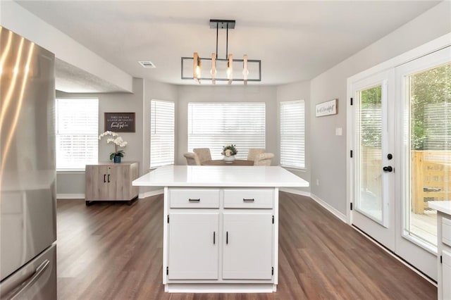 3132 Wellborne Dr W, Mobile, AL 36695 - kitchen featuring freestanding refrigerator, light countertops, dark wood-style flooring, white cabinetry, and pendant lighting