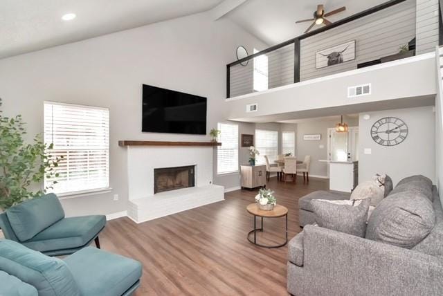3132 Wellborne Dr W, Mobile, AL 36695 - living room featuring a ceiling fan, a fireplace with raised hearth, beam ceiling, wood finished floors, and high vaulted ceiling