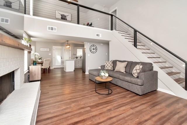 3132 Wellborne Dr W, Mobile, AL 36695 - living room featuring a high ceiling, wood finished floors, stairway, and a brick fireplace