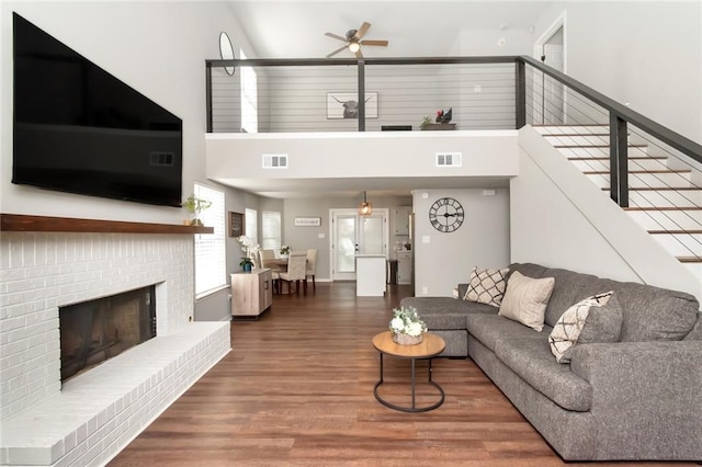 3132 Wellborne Dr W, Mobile, AL 36695 - living room with ceiling fan, a high ceiling, wood finished floors, a brick fireplace, and stairs