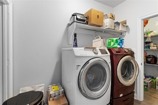 washroom with hardwood / wood-style floors and washing machine and clothes dryer