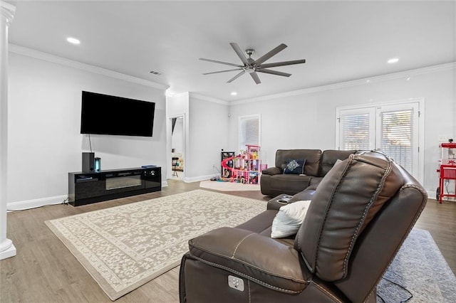 living room featuring hardwood / wood-style floors, ceiling fan, and ornamental molding