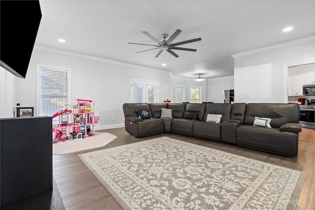 living room featuring hardwood / wood-style flooring, ceiling fan, and crown molding