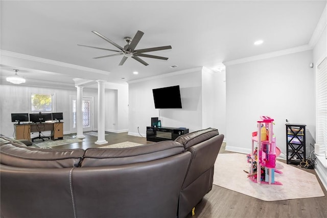 living room with ceiling fan, wood-type flooring, crown molding, and ornate columns