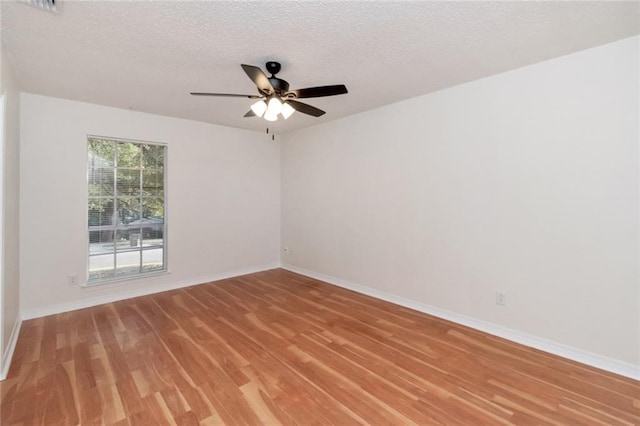 unfurnished room with hardwood / wood-style flooring, ceiling fan, and a textured ceiling