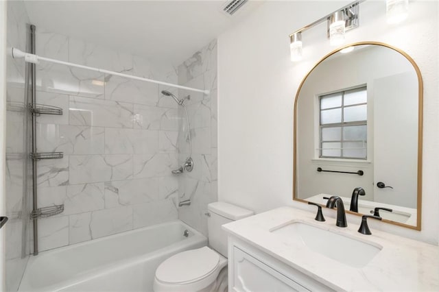 full bathroom featuring vanity, tiled shower / bath combo, and toilet