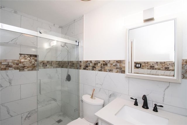 bathroom with vanity, toilet, an enclosed shower, and tile walls