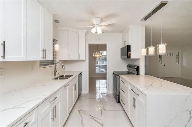 kitchen with light stone counters, white cabinets, sink, appliances with stainless steel finishes, and decorative light fixtures