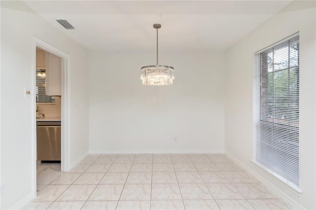 tiled empty room featuring a chandelier