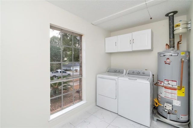 washroom featuring cabinets, gas water heater, and independent washer and dryer