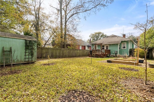 view of yard featuring a wooden deck and a shed