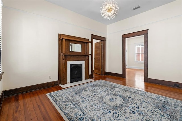 unfurnished living room featuring dark wood-type flooring and a chandelier