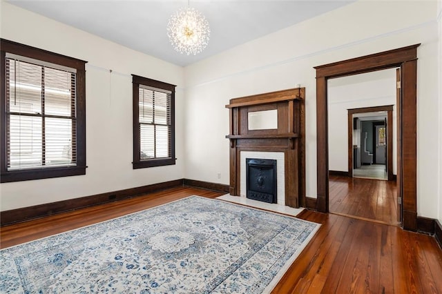 unfurnished living room featuring a chandelier and dark hardwood / wood-style flooring