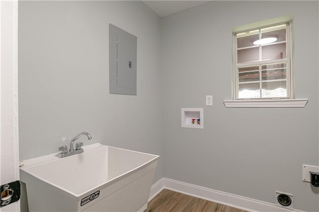 washroom featuring washer hookup, light hardwood / wood-style floors, sink, and electric panel