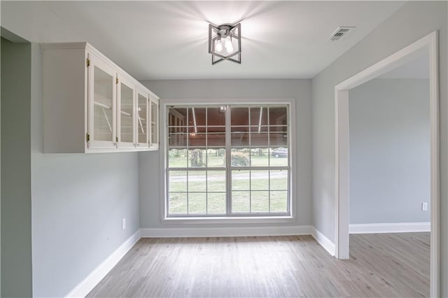 unfurnished dining area with light wood-type flooring