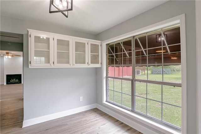 unfurnished dining area with a fireplace and light hardwood / wood-style flooring