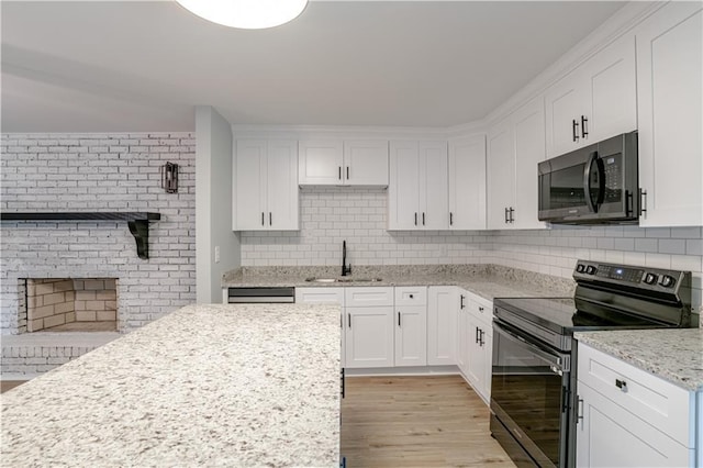 kitchen featuring white cabinets, light stone counters, sink, light hardwood / wood-style flooring, and black electric range