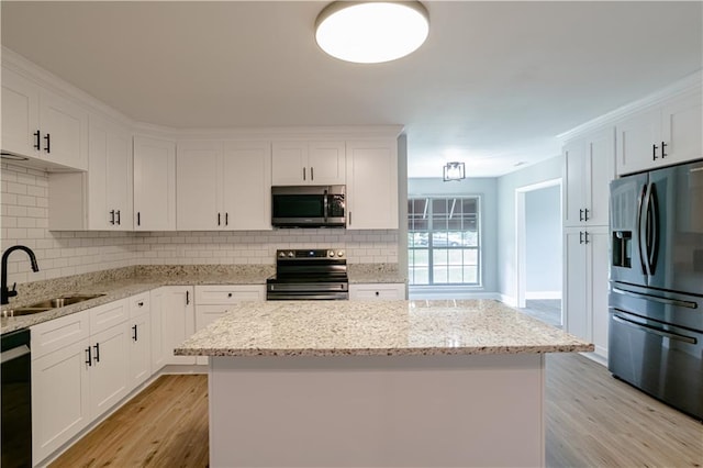 kitchen featuring white cabinetry, sink, a kitchen island, and stainless steel appliances